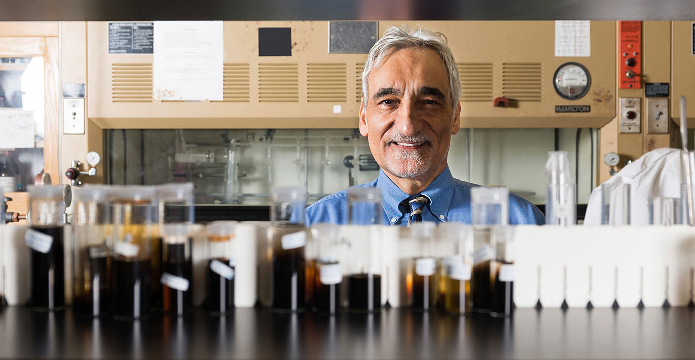 George Christou peers over row of vials