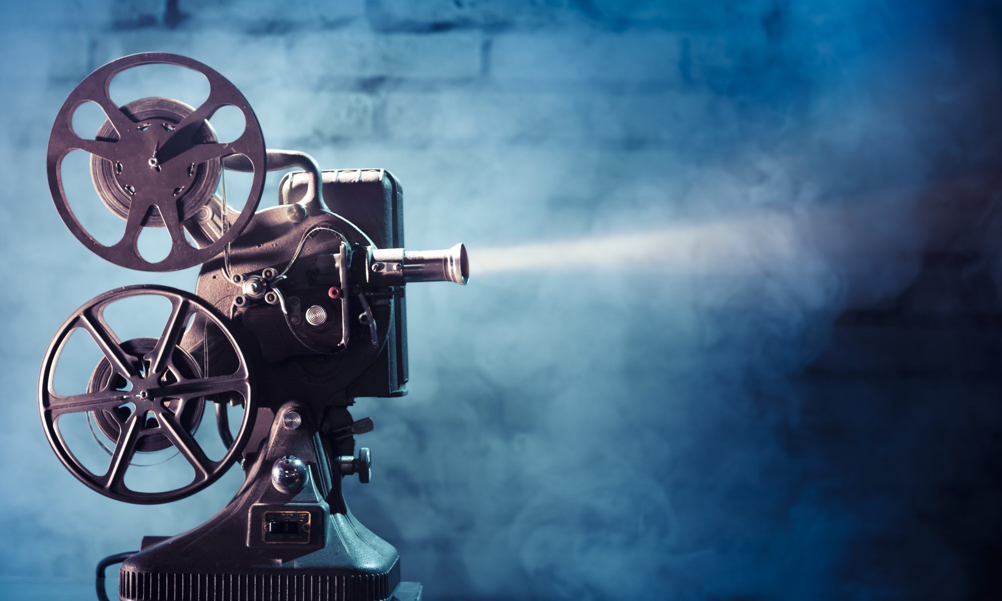 old fashioned film projector on blue background