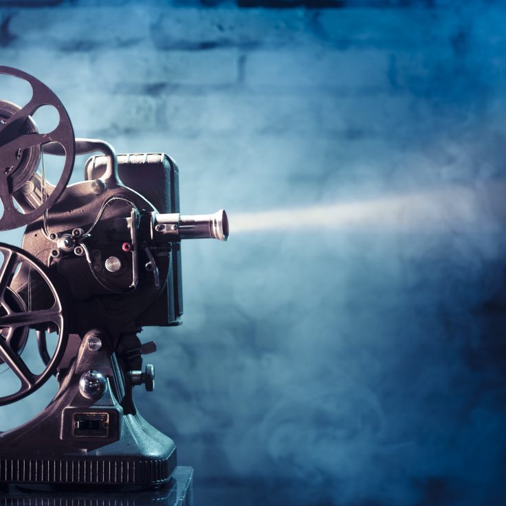 old fashioned film projector on blue background