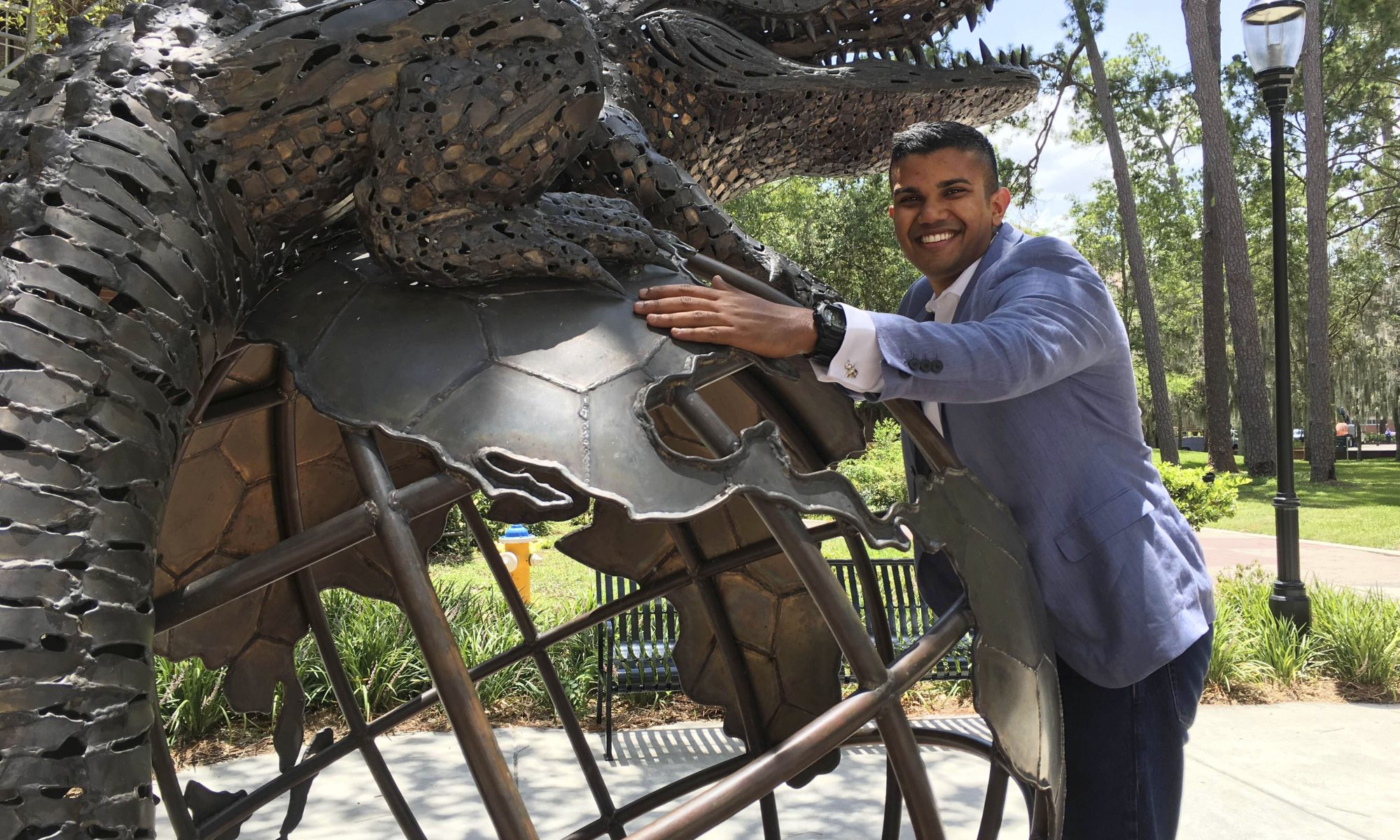 Portrait of Nirav Patel with the global gator statue