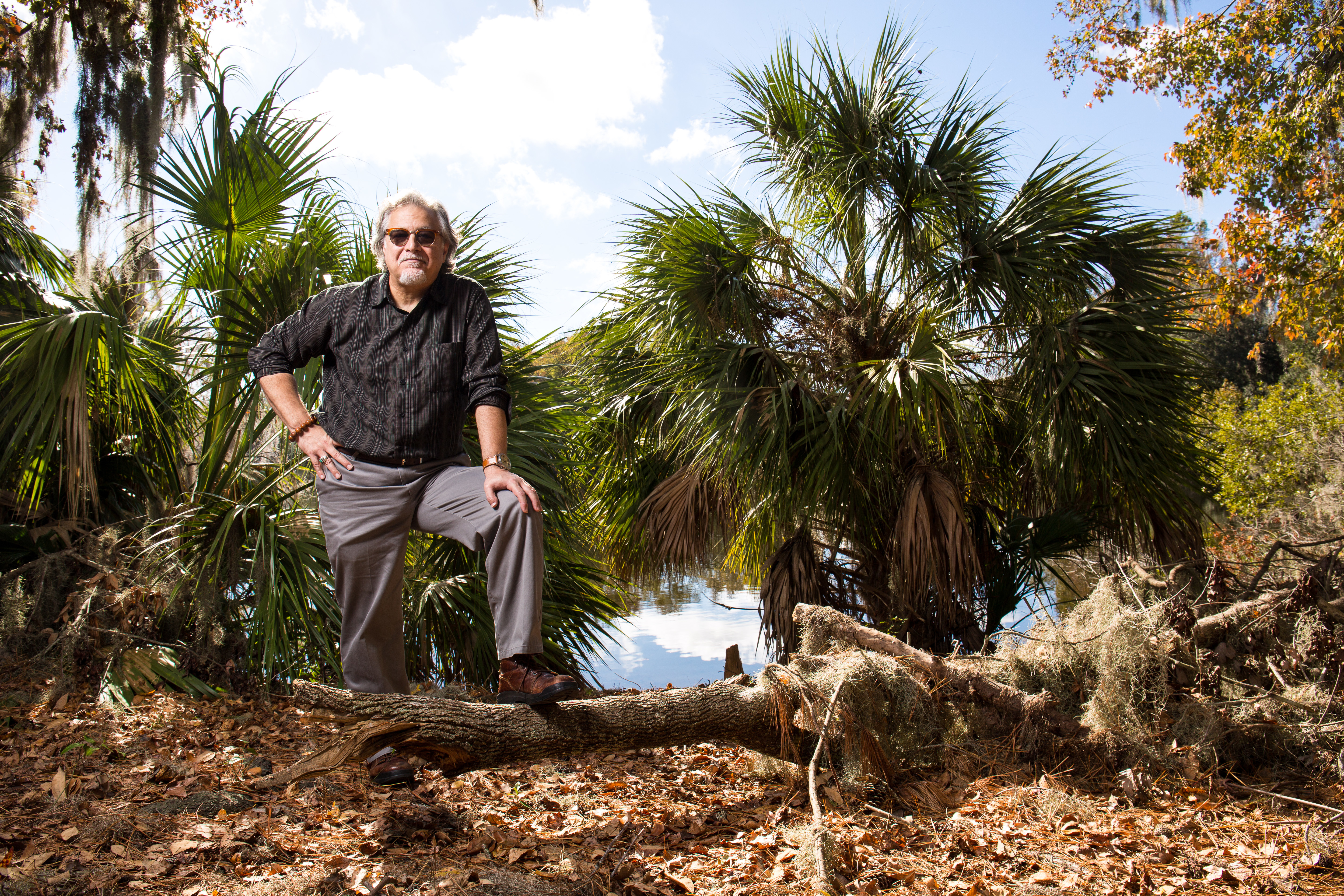 Thomas Bianchi stands on a fallen tree by Lake Alice