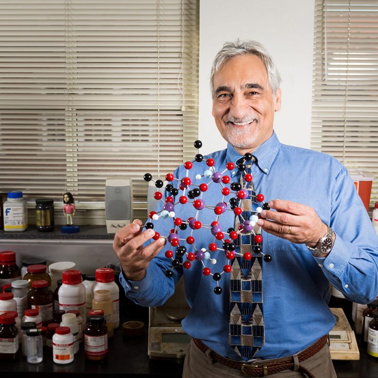 Photo of Professor Christou holding a molecule model.