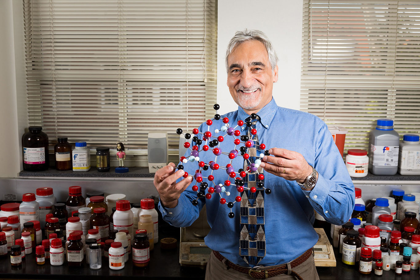 Photo of Professor Christou holding a molecule model.