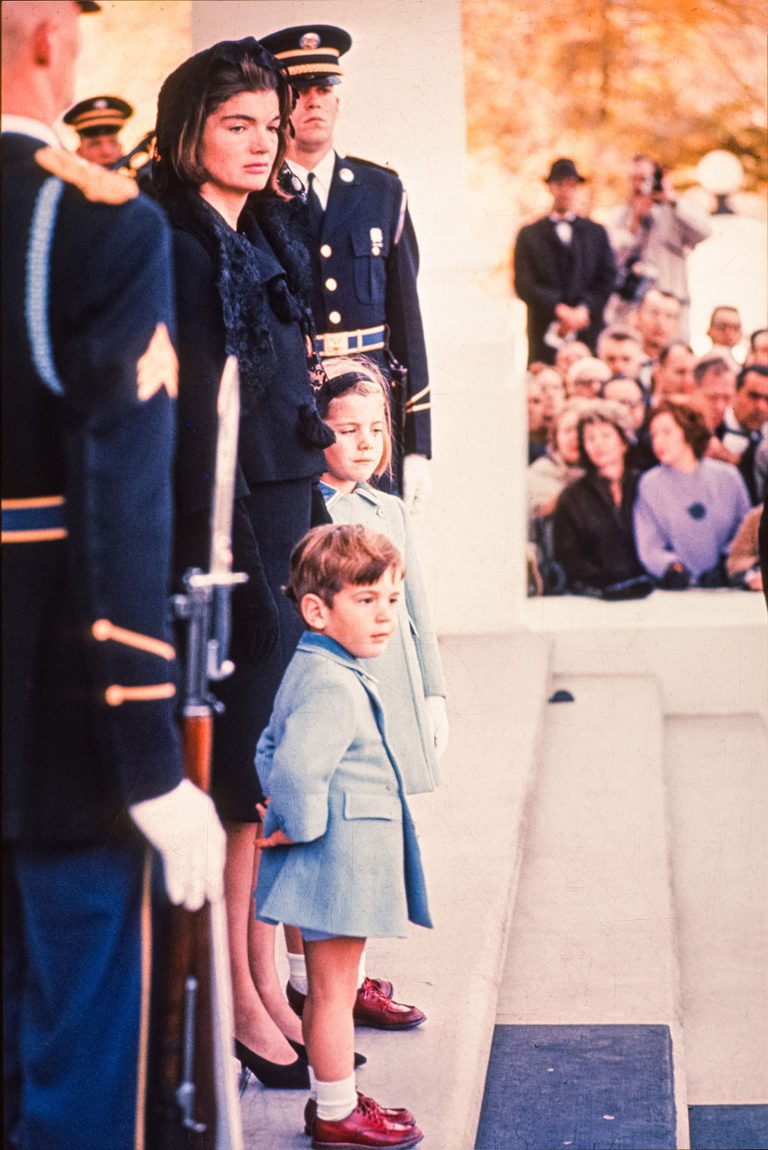Mourning Jackie Kennedy and her children stand with military guard