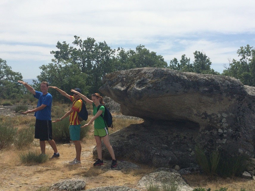 Hikers do Gator Chomp by large rock