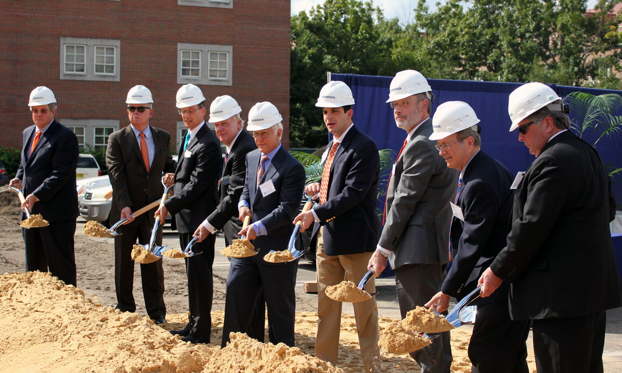 A group of men hold shovels at the ceremonial groundbreaking