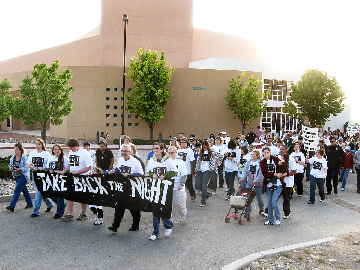 photo of women marching holding signs that read Take Back the Night