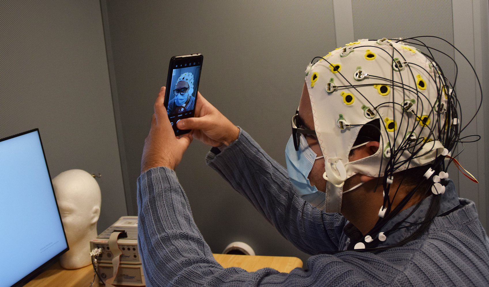 Reinaldo Cabrera Pérez takes a selfie while wearing an electroencephalography (EEG) cap.