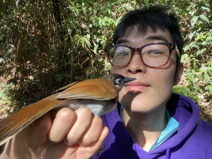 Wenyi holding a Gray-sided Laughingthrush during fieldwork in southwestern China. 