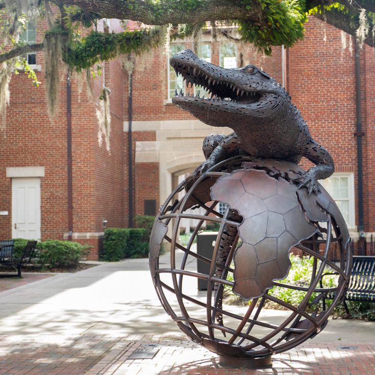 Gator sculpture with globe design on campus