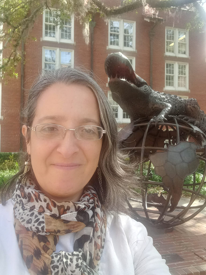 Maria Victoria Munoz taking a selfie in front of a statue on UF campus