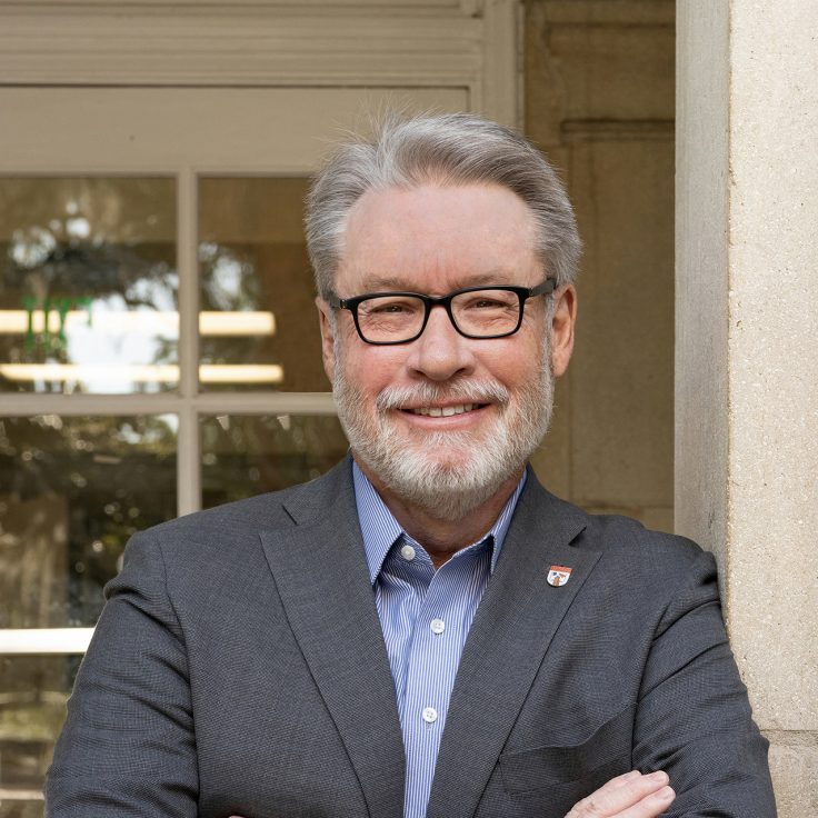 Dean Richardson stands in front of an academic building