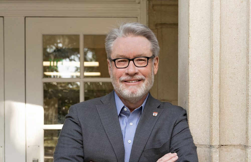 Dean Richardson stands in front of an academic building