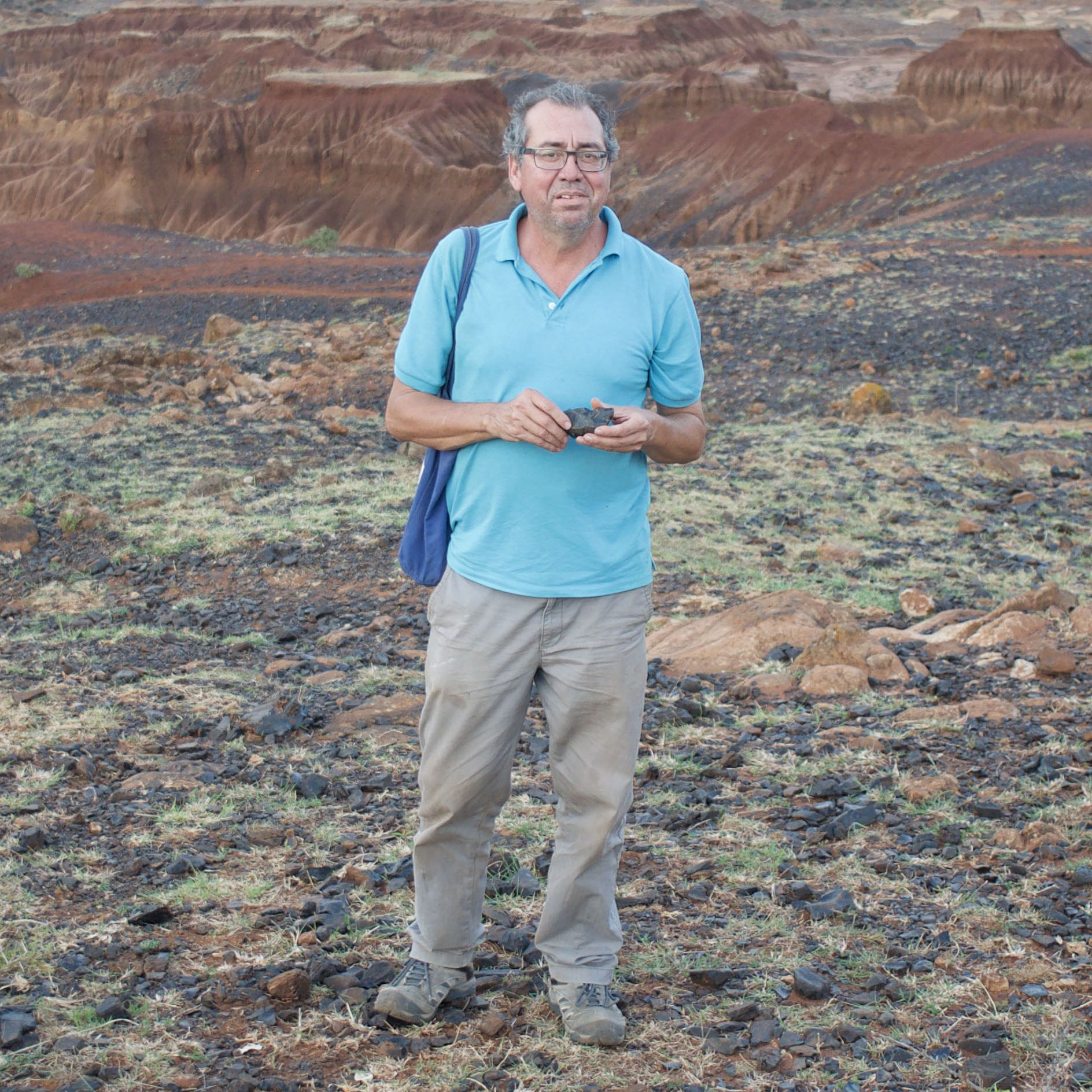 Augusto Oyuela-Caycedo standing on rocky terrain near some mountains