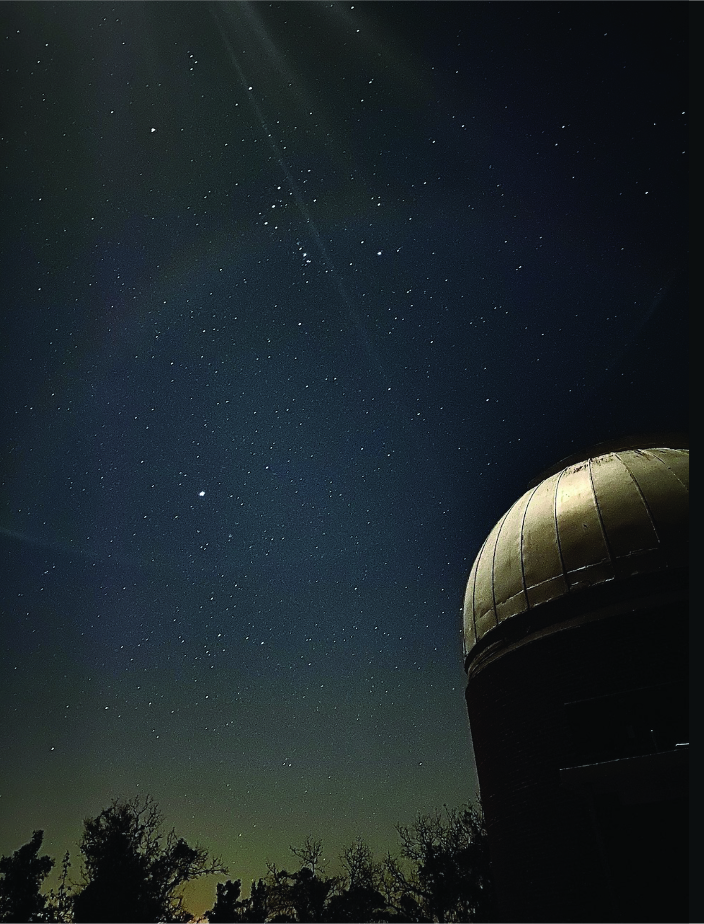 A low-angle shot of the Rosemary Hill Observatory's dome, with many stars visible in the background. 