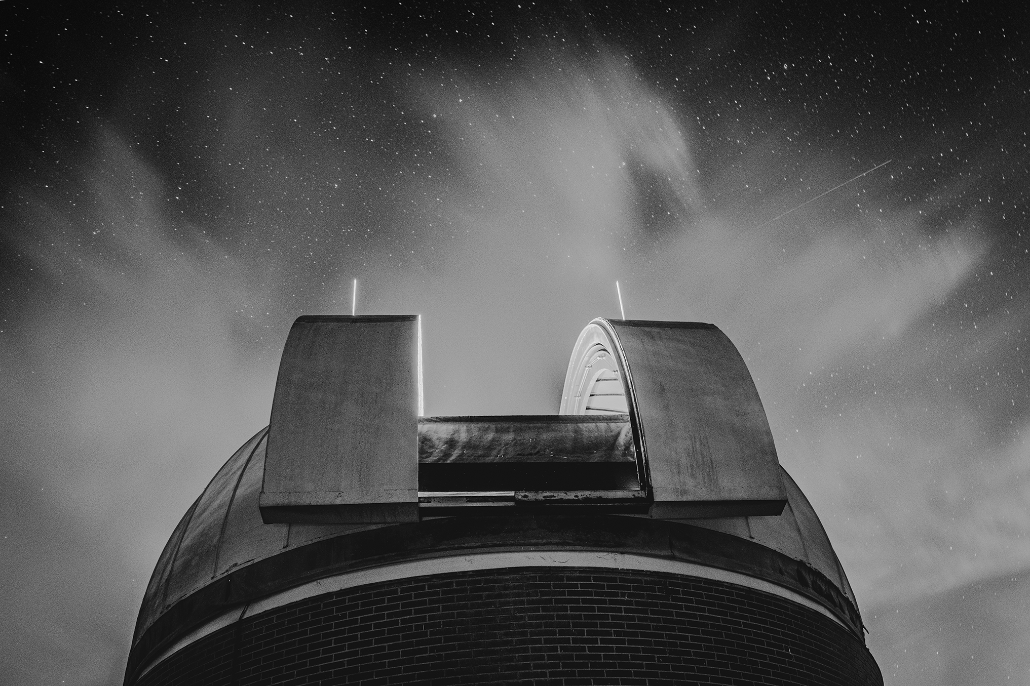 A black and white photo of Rosemary Hill's larger tower, with the night sky dotted with stars in the background. 