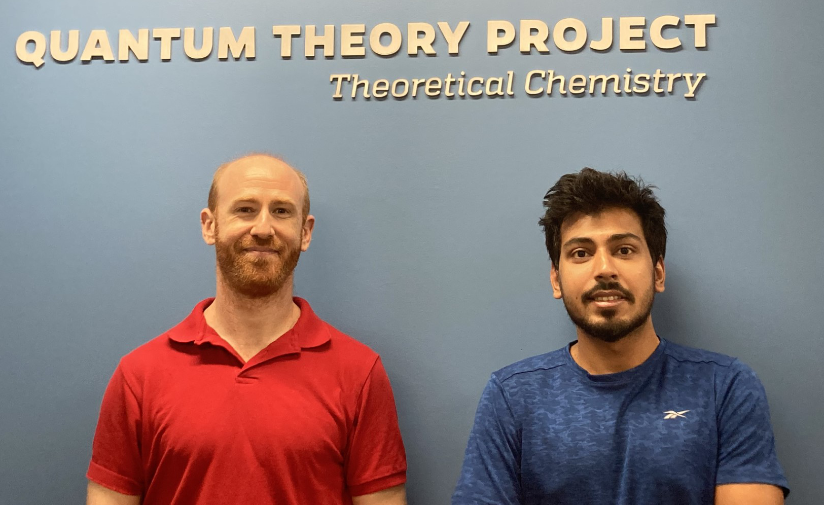 Alberto Perez and Arup Mondal pose in front of a sign reading "Quantum Theory Projects."