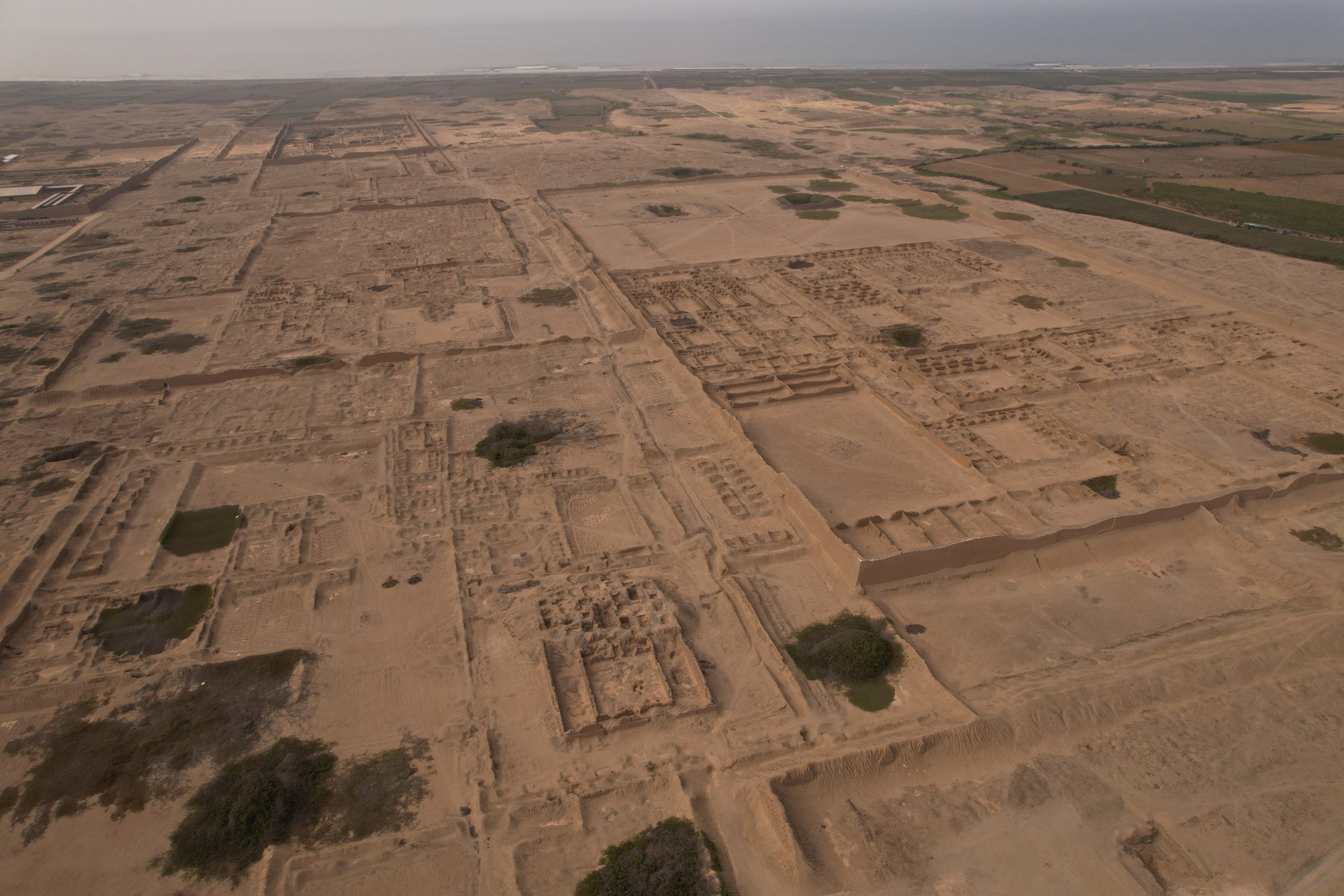 An aerial view of an excavation site, showing the ruins and remains of the town's walls and canals. 
