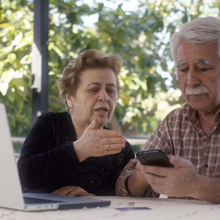 An older couple looks at a cellphone