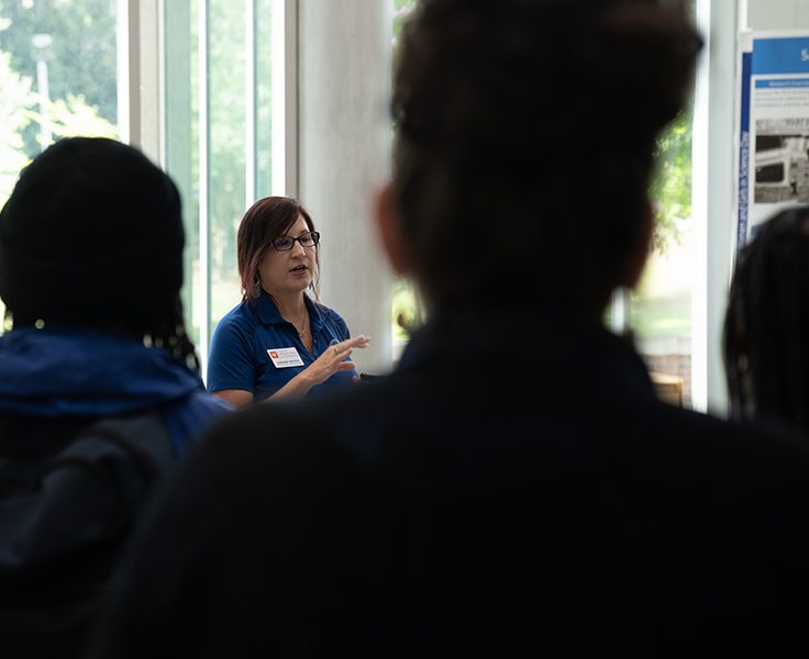 woman speaks to a group of students