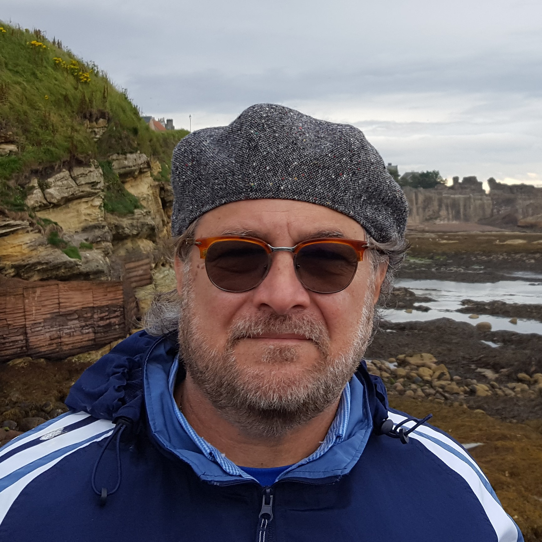 Thomas Bianchi standing in front of a rocky beach in Scotland.