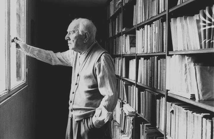 Man standing at bookshelf.