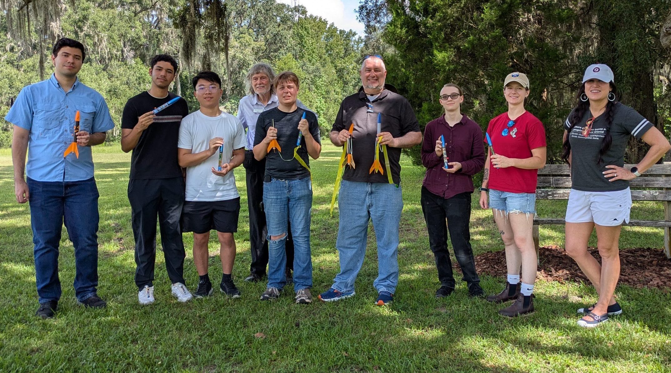 Group of students and teacher with rocket.