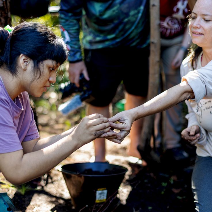 two women examine a ceramic shard